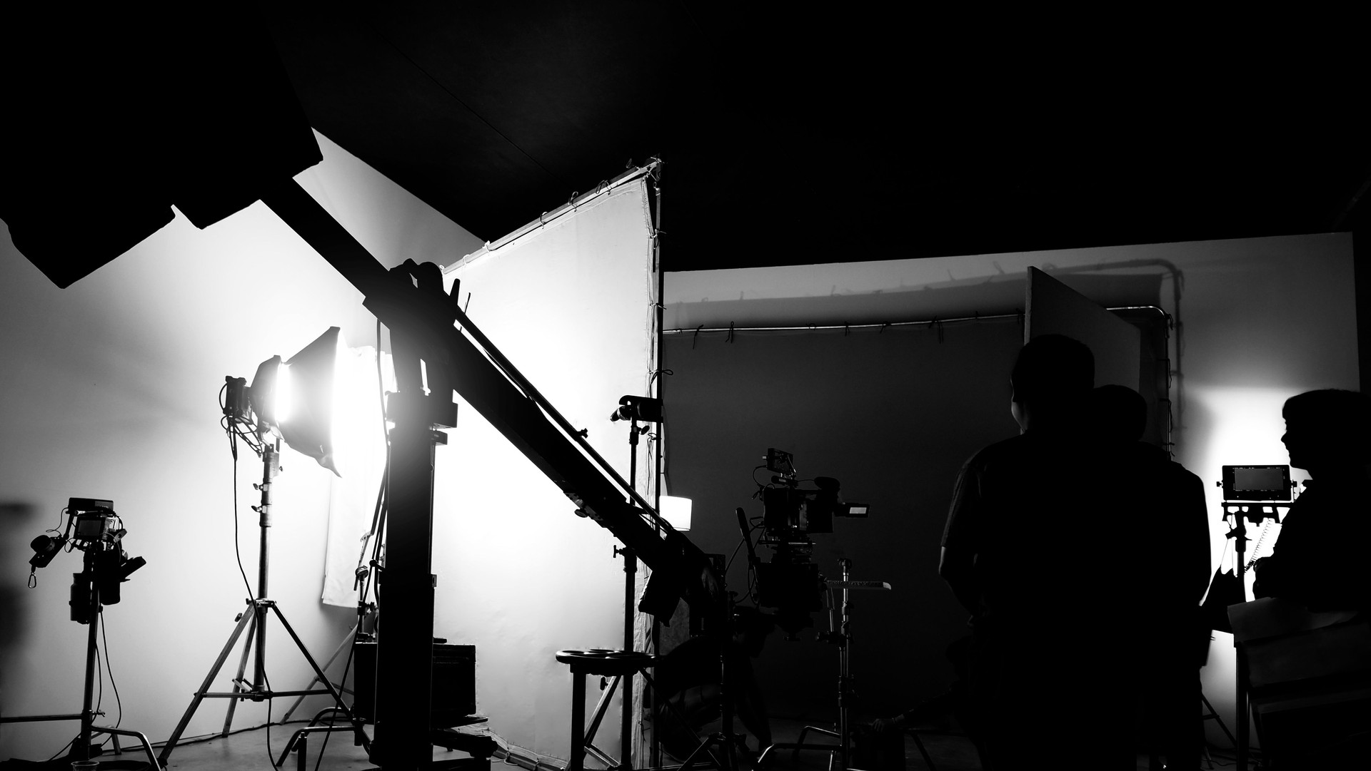 Silhouette images of making of or behind the scenes of video production which produced in the film studio that include all pro light and camera equipment and professional film crew with movie director